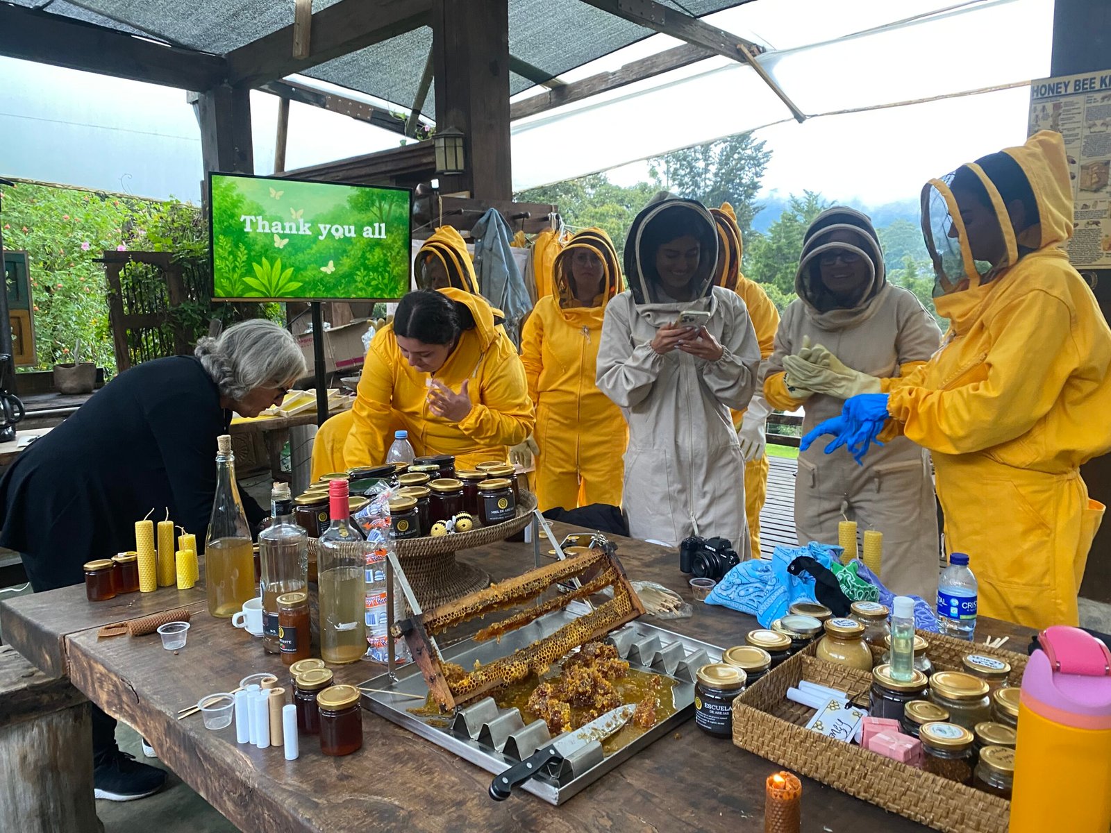 Apicultor de Escuela de Abejas mostrando un panal a un grupo de personas en una visita guiada.